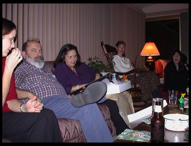 Heather, Grandpa and Grandma watching Grandma open her gift exchange present.