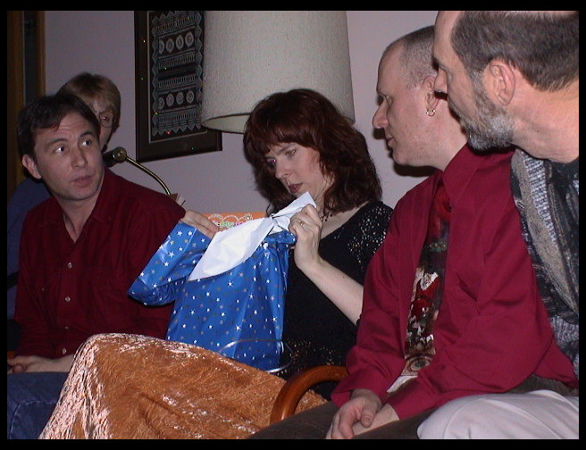 The guys seem interested in what Jen is unwrapping.