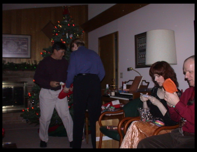 Kate and Greg giving stockings to each other.