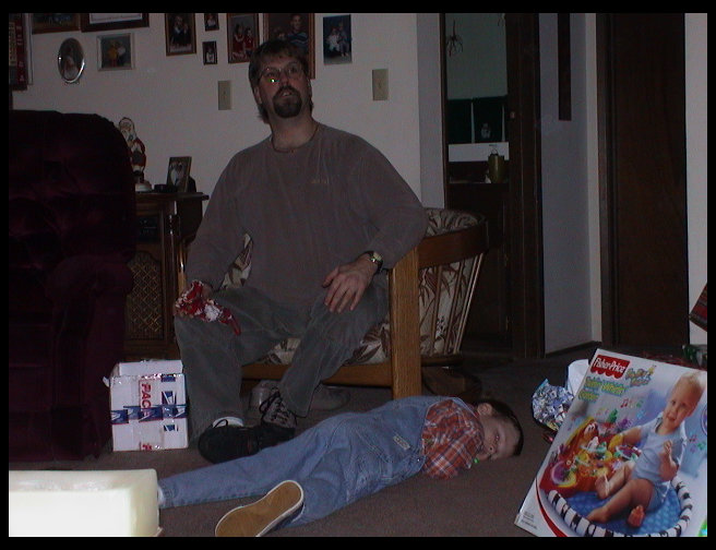 Uncle Dave looking at something across the room and Kaleb on the floor.