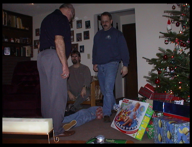 Grandpa, Uncle Dave, Uncle Ron and Kaleb putting stocking stuff away.