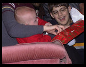 Now Tyler is helping Logan open a present.