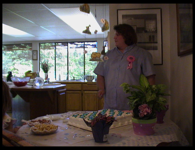 Sandra deciding how to cut the cake.
