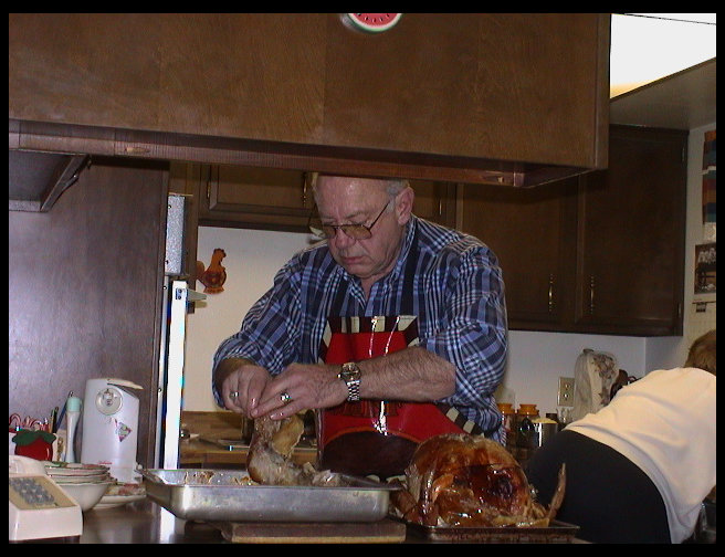 Grandpa Trogdon carving the turkey for Thanksgiving dinner.