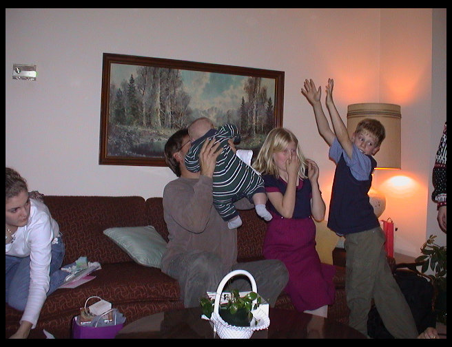 Jen putting presents away, Uncle Dave holding Logan, Lisa and Erik hamming it up.