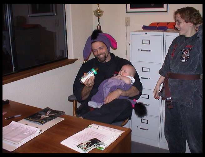 Mr. Graves pretending not to enjoy holding Logan, Ms.  McKennon laughing.