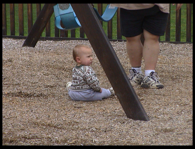 Logan sitting down in the playground.