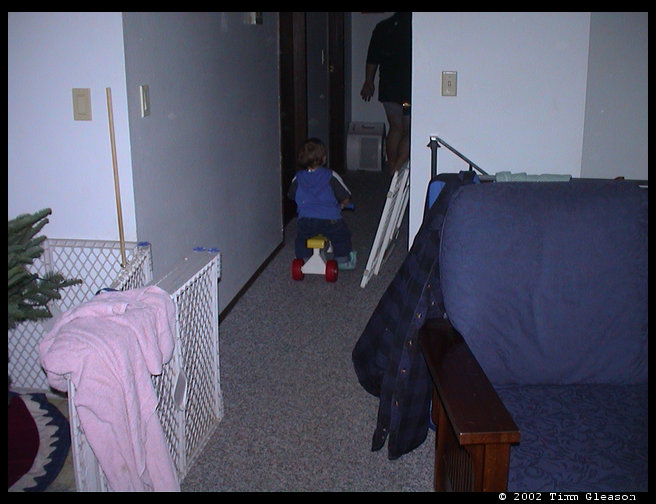 Logan riding his bike down the hall.