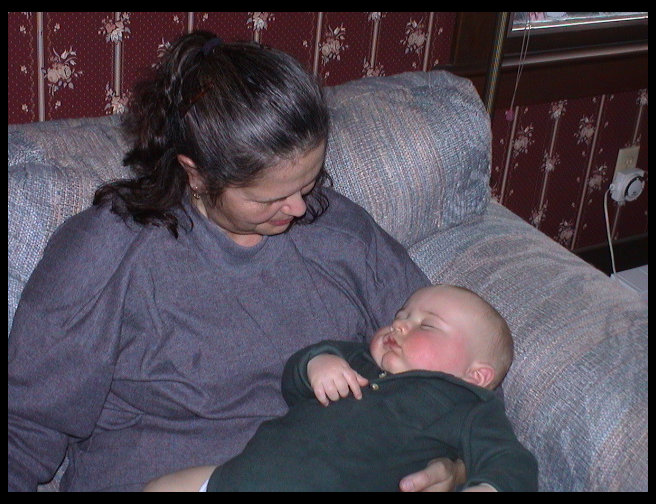 Grandma Zoe holding a tired boy on Grandpa Rick's birthday.