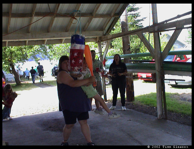 Sandra helping Rebecca break the pinata open.