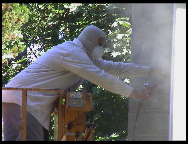 Thom painting the side of the house.