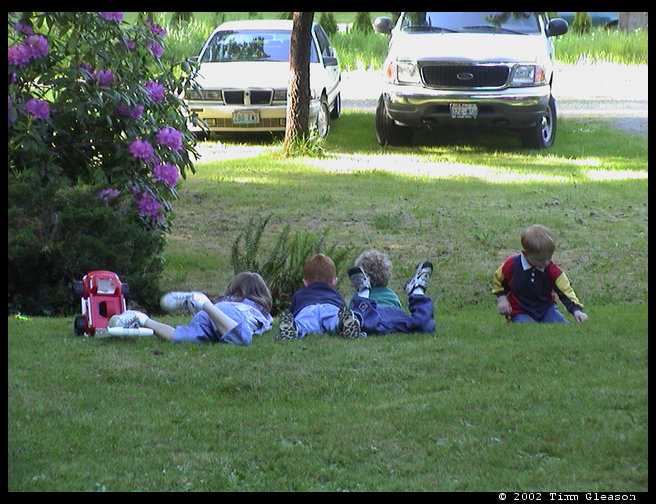 Kids relaxing on the grass after playing hard.