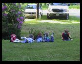 Kids relaxing on the grass after playing hard.