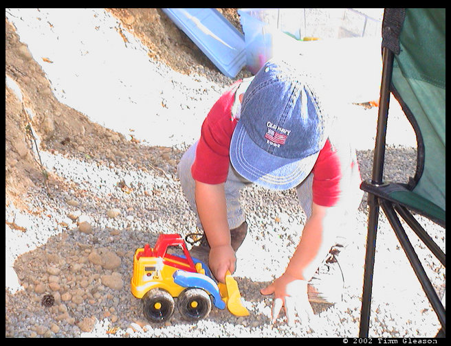 Logan putting pea gravel in the front end loader. 