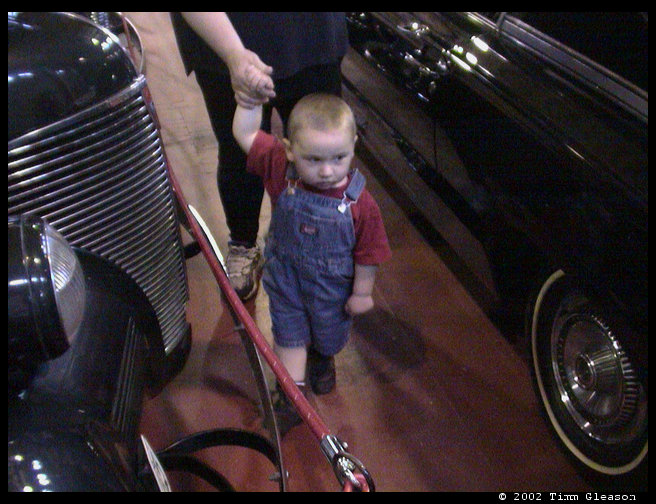 Logan leading mommy through the cars.