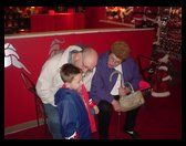 Grandma and Grandpa Trogdon waiting with Logan to see Santa